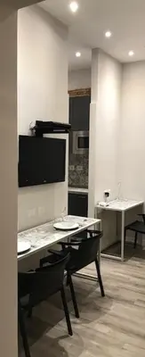 a living room with a table and a tv on the wall at Rome Studio Rental in Rome