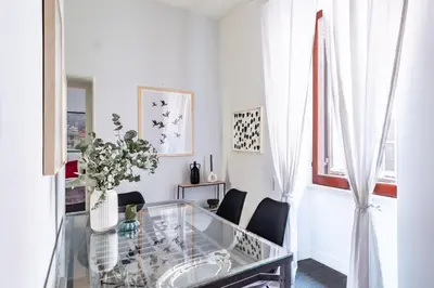 a white living room with a glass table and chairs at Monserrato Historical by Campo de' Fiori in Rome