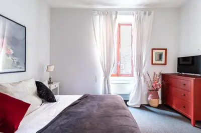 a bedroom with a bed with a red dresser and a window at Monserrato Historical by Campo de' Fiori in Rome