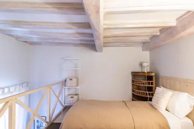 a bedroom with white walls and wooden ceilings and a bed at Monserrato Historical by Campo de' Fiori in Rome