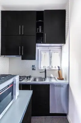 a kitchen with black cabinets and a sink at Monserrato Historical by Campo de' Fiori in Rome
