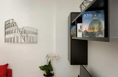a book shelf with a picture of the coliseum at Porta Latina Suite - Private Apartment Rome's Center in Rome