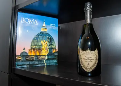 a bottle of wine sitting on a table next to a painting at Porta Latina Suite - Private Apartment Rome's Center in Rome