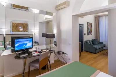 a room with a bed and a desk with a television at Les Diamants in Rome