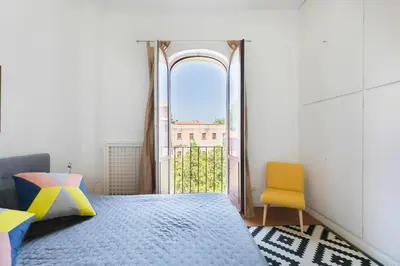 a bedroom with a bed and an open window at Trastevere Charming Penthouse in Rome