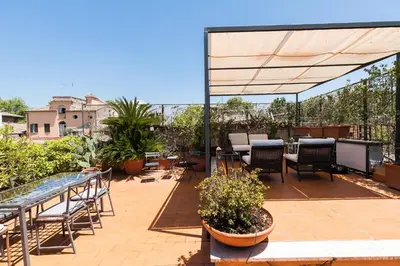 a patio with tables and chairs under a canopy at Trastevere Charming Penthouse in Rome