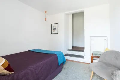 a bedroom with a bed and a chair and a window at Trastevere Charming Penthouse in Rome