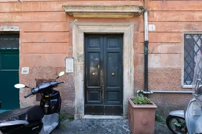 a scooter parked in front of a building with a door at Trastevere Charming Penthouse in Rome