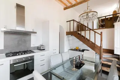 a kitchen with a glass table and a staircase at Trastevere Charming Penthouse in Rome