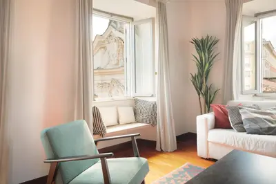 a living room with a couch and a chair and a window at Farnese Apartment 1870 in Rome