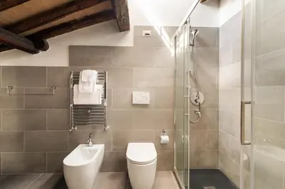 a bathroom with a toilet and a glass shower at Farnese Apartment 1870 in Rome