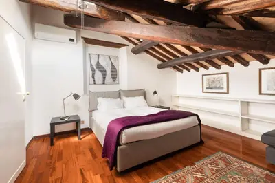 a bedroom with a bed in a room with wooden ceilings at Farnese Apartment 1870 in Rome