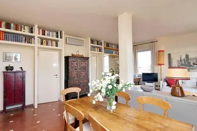 a living room with a table with flowers on it at Sant'Onofrio Terrace Apartment in Rome