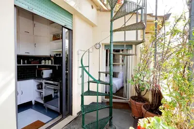 a green spiral staircase in a kitchen with a kitchen at Sant'Onofrio Terrace Apartment in Rome