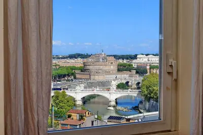 a window with a view of a bridge and a river at Sant'Onofrio Terrace Apartment in Rome