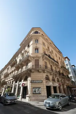 a building with two cars parked in front of it at 900 Apartments Lazio, Emilia & La Corte in Rome
