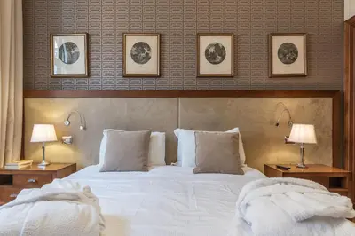 a bedroom with a large white bed with two lamps at 900 Apartments Lazio, Emilia & La Corte in Rome