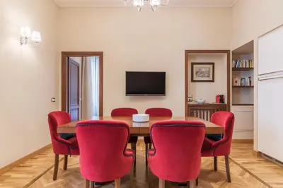 a dining room with a table and red chairs at 900 Apartments Lazio, Emilia & La Corte in Rome