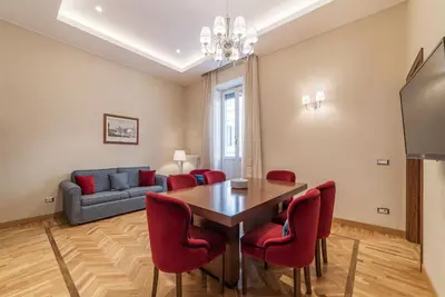 a dining room with a table and red chairs at 900 Apartments Lazio, Emilia & La Corte in Rome