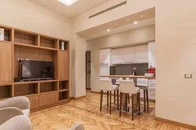 a kitchen and living room with a bar with stools at 900 Apartments Lazio, Emilia & La Corte in Rome