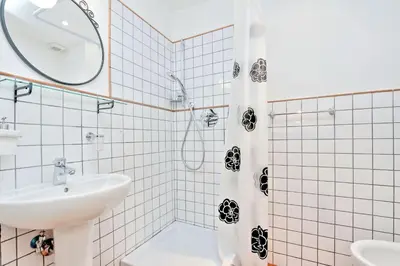 a white bathroom with a sink and a shower at Le 2 Basiliche - Esquilino Retreat in Rome