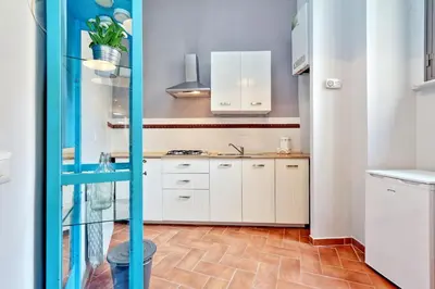 a kitchen with white cabinets and a tile floor at Le 2 Basiliche - Esquilino Retreat in Rome