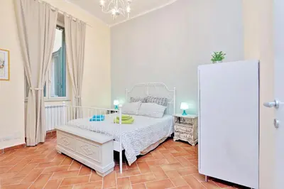 a bedroom with a white bed and a white refrigerator at Le 2 Basiliche - Esquilino Retreat in Rome