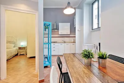 a kitchen and a living room with a table and chairs at Le 2 Basiliche - Esquilino Retreat in Rome