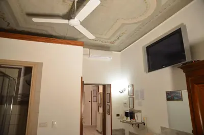 a living room with a ceiling fan and a flat screen tv at Roma sogno infinito in Rome