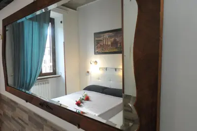 a mirror reflecting a bedroom with a bed in a room at Roma sogno infinito in Rome