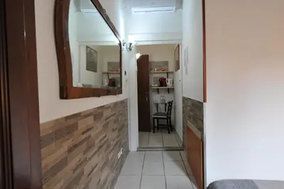 a hallway with a mirror and a chair in a room at Roma sogno infinito in Rome