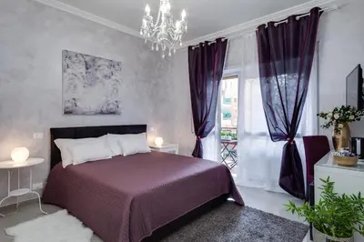 a bedroom with a purple bed and a chandelier at Dreamsrome Suites in Rome