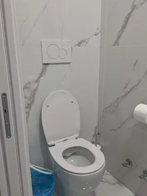 a bathroom with a white toilet and marble walls at Relax ON 247 in Rome