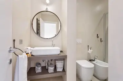 a bathroom with a sink and a mirror and a toilet at Rome as you feel - Vatican Terrace Apartments with View in Rome