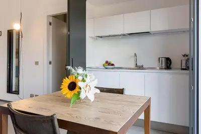 a table with a vase of flowers on it in a kitchen at Rome as you feel - Vatican Terrace Apartments with View in Rome