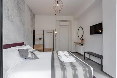 a bedroom with a large white bed and a mirror at Rome as you feel - Vatican Terrace Apartments with View in Rome