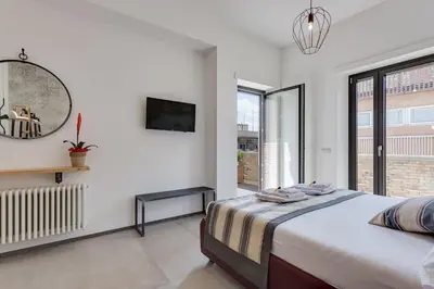 a white bedroom with a bed and a window at Rome as you feel - Vatican Terrace Apartments with View in Rome