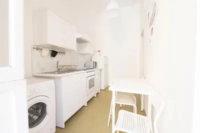 a white kitchen with a washing machine and a washer at Praetorian apartment in Rome