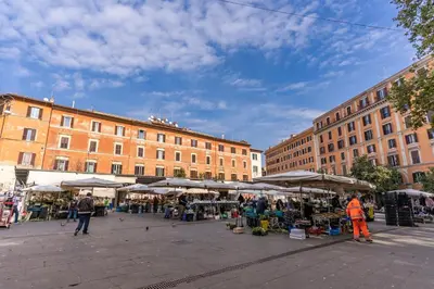 a market in a city with buildings and people walking around at Locanda San Cosimato in Rome