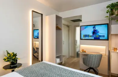 a bedroom with a bed and a television on a wall at Leonardo Boutique Hotel Rome Termini in Rome
