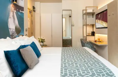 a bedroom with a large bed with blue pillows at Leonardo Boutique Hotel Rome Termini in Rome