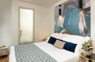 a bedroom with a white bed and a blue wall at Leonardo Boutique Hotel Rome Termini in Rome