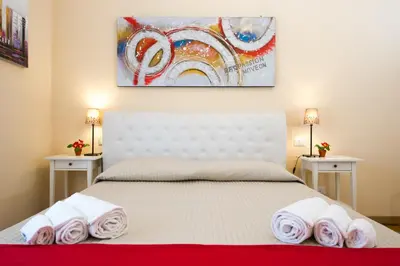 a bedroom with a white bed with towels on it at House Gregorio in Rome