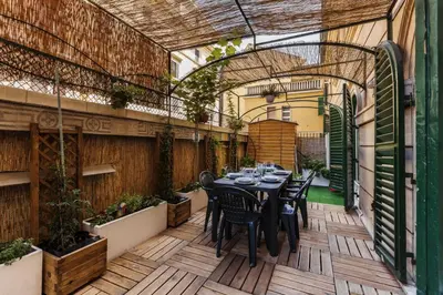 a patio with a table and chairs on a wooden deck at The Sweet Terrace in Rome