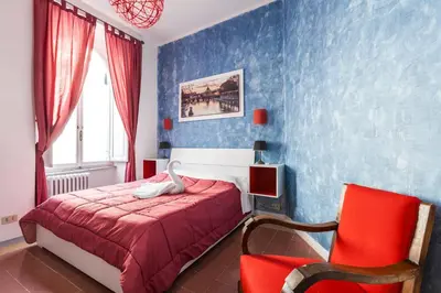 a bedroom with a bed and a red chair at The Sweet Terrace in Rome