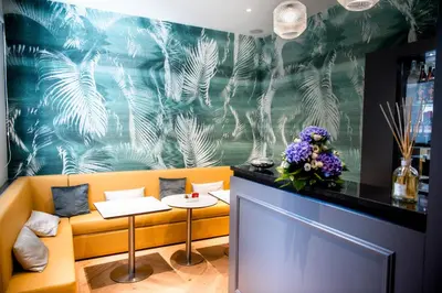 a restaurant with a yellow booth with flowers on the wall at Boutique Centrale Palace Hotel in Rome
