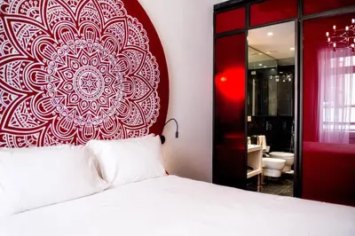 a bedroom with a bed with a red mandala wall at Boutique Centrale Palace Hotel in Rome