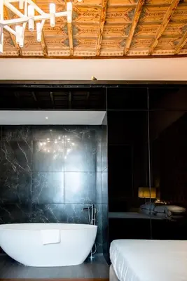 a bathroom with a bath tub and a bed at Boutique Centrale Palace Hotel in Rome