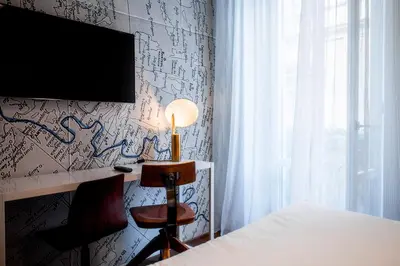 a bedroom with a bed and a tv on a wall with graffiti at Boutique Centrale Palace Hotel in Rome