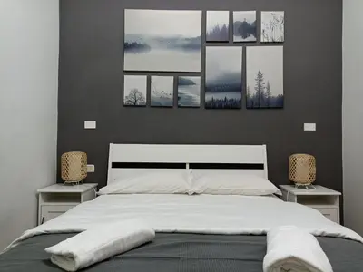 a bedroom with a bed with four paintings on the wall at Martini Rooms in Rome